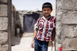 Mohammad stands in the doorway to his house in the Domiz Refugee Camp